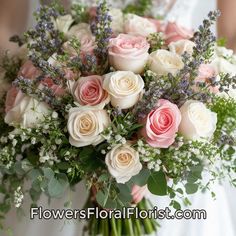 a bride holding a bouquet of white and pink roses