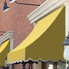 an awning on the side of a building next to a street light and lamp post