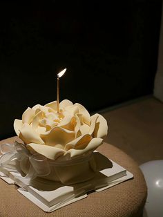 a candle that is sitting in a bowl on a table next to some napkins