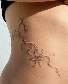 a woman's stomach with an intricate tattoo design on the bottom part of her belly