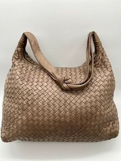 Early 2000's Bottega Veneta Intrecciato large hobo bag with top knot on the handle.  I believe that this design is the precursor to BV's current Jodie handbag which is currently one of the "IT" bags. The body is entirely woven with buttery soft taupe leather.  It is in nice condition with some rubbing on the top knot of the strap.  No holes, tears, creases, stains or rips.  Clean interior.  Wonderful neutral color for the spring and summer. Approx. measurements:  13"W x 11"H x 6"D;  Shoulder strap drop 12" *Shipping rate reflects added insurance costs with USPS.  If you would like me to use UPS or Fed Ex, please contact me PRIOR to purchasing so that I can give you an estimate for shipping and added insurance costs.  Changes in shipping carriers cannot be made after the transaction. Designer Tote Shoulder Bag With Interwoven Design, Luxury Hobo Bag With Interwoven Design For Everyday Use, Everyday Use Top Handle Hobo Bag With Interwoven Design, Designer Rectangular Hobo Bag With Braided Handles, Elegant Rectangular Hobo Bag With Interwoven Design, Designer Shoulder Bag With Interwoven Design For Daily Use, Elegant Hobo Shoulder Bag With Interwoven Design, Elegant Beige Hobo Bag With Intrecciato Weave, It Bags