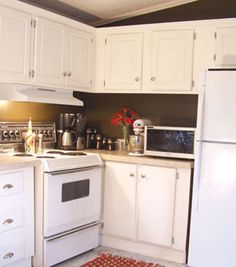 a kitchen with white cabinets and appliances