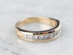 a close up of a wedding ring on a marble surface with white and black diamonds