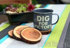 two pieces of wood sitting on top of a table next to a mug with the words dig for victory