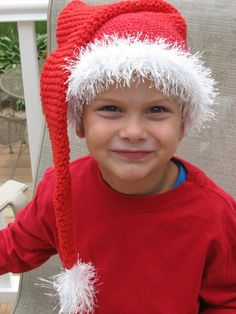 a young boy wearing a knitted santa hat