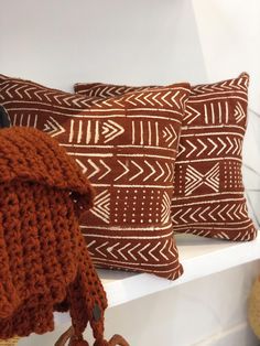 two brown pillows sitting on top of a white shelf