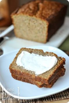 two slices of bread on a white plate with cream cheese in the middle and another piece of bread next to it