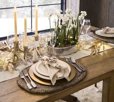 a table set with plates, silverware and flowers