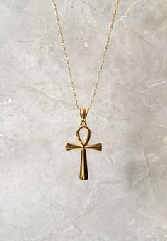 The necklace and pendant are 18kt gold plated over stainless steel. Gold Spiritual Cross Necklace In Stainless Steel, Gold Stainless Steel Spiritual Cross Necklace, Gold Stainless Steel Cross Jewelry, Yellow Gold Stainless Steel Cross Pendant Necklace, Gold Stainless Steel Pendant Cross Necklace, Gold Stainless Steel Cross Necklace As Gift, Gold Stainless Steel Cross Necklace For Gift, Gold Ankh Necklace With Adjustable Chain, Gold Ankh Necklace Gift