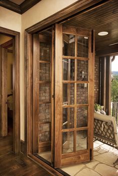 an open door leading to a patio with brick walls and wood trimming on the outside