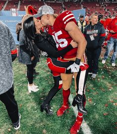 a man and woman kissing on the football field