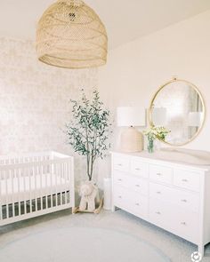 a baby's room with a crib, dresser and mirror