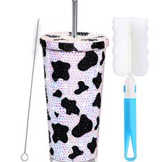 the toothbrush holder is decorated with black and white cow print, while the toothbrush holders are blue and white