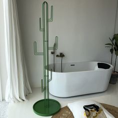 a white bath tub sitting next to a tall green cactus plant in a living room