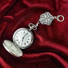 This delightful full size vintage style pocket watch adds a touch of classic Victorian flair to your chatelaine! This beautiful chatelaine pocket watch features a silver colored mirror like finish on the front and back covers. Intricate details like the pearlized watch face and classic Roman numerals add even more vintage detail and charm.  The removable chatelaine chain has an elaborate floral filigree ornament at its center, while a large scrolled loop at the top makes it easy to attached or removed from your chatelaine. This multi-functional pocket watch also comes with an elegant fob chain so you can wear it more than one way! The chain is formed with a high quality Cuban style chain, with a clip/hook on one end for attaching to a belt or pocket and a large heart clasp on the other for Intricate Pocket Watch, Luxury Silver Pocket Watch Collectible, Victorian Watch, Cuban Style, Colored Mirror, Floral Filigree, Silver Pocket Watch, Large Heart, Pocket Watches