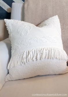 a white pillow sitting on top of a couch next to a blue and white striped wall