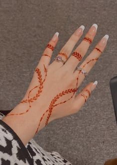 a woman's hand with hennap and rings on her left wrist, next to a laptop computer