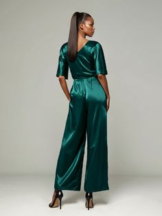 This soft satin jumpsuit features a flattering v-neck design, making it the perfect choice for mothers of the bride. Its dress pantsuit style provides comfort and elegance, while its high-quality material ensures a polished look. Stay stylish and comfortable on that special day with our jumpsuit. Silk V-neck Party Sets, Chic Satin Suits For Evening, Chic Satin Evening Suits, Chic Evening Suits In Satin, Elegant Satin Sets For Workwear, Satin Evening Sets, Elegant V-neck Sets For Workwear, Elegant Satin Pantsuit For Evening, Elegant V-neck Evening Pantsuit