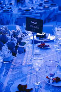 the table is set for an event with place cards and wine glasses on it,