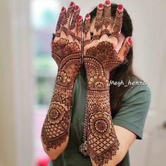 a woman holding her hands up with hendi tattoos on it's palms and arms