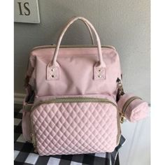 a pink purse sitting on top of a black and white checkered floor