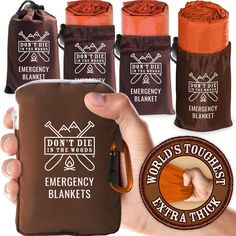 a person is holding an emergency blanket in front of four different pouches with the words don't die at the woods and emergency blankets printed on them