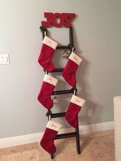 a ladder with stockings hanging from it and the word joy spelled on top in red