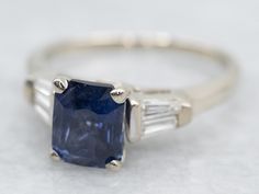 an engagement ring with a blue sapphire and baguettes