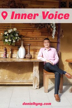 a man sitting on a bench in front of a table with vases and flowers