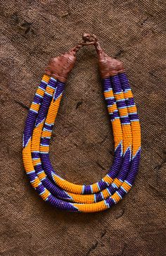 This Beaded Statement Collar is a classic and stylish African tribal necklace crafted using traditional tribal techniques. Featuring eco-friendly, colorful beads in a tribal pattern, this necklace is perfect for making a statement and will be a beautiful addition to any wardrobe. 9 inches Traditional Handmade Purple Beaded Necklaces, Traditional Purple Beaded Necklace With Round Beads, Traditional Brown Beaded Necklace With Colorful Beads, Traditional Brown Beaded Necklace With Multicolored Beads, Statement Jewelry Necklace, Statement Collar, Beaded Collar, Necklace Craft, African Pattern