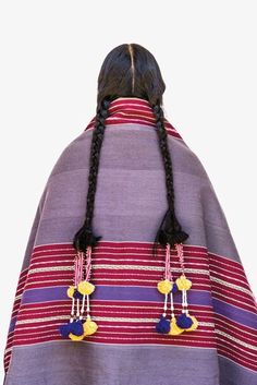 the back of a woman's head wearing a purple and red striped shawl