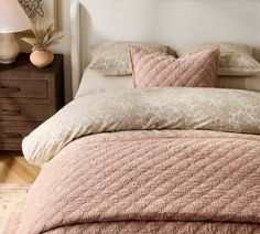 a bed with pink and beige comforters in a bedroom