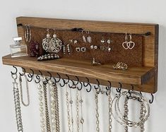 a wall mounted jewelry rack with several pairs of earrings hanging from it's sides