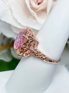 Pink Cubic Zirconia Ring Speechless Design#103 Custom Made Inspired by Victorian era filigree designs, I now offer this stunning Antique inspired ring in rose gold plated sterling silver. This fabulous ring is set with a 6ct flawless Pink Cubic Zirconia gemstone. The round full cut high-quality pink gemstone is 12mm (just shy of 1/2th of an inch) in diameter. The inside of the band is marked 925 for sterling. Notice the beautiful intricate bow and floral-like design of the silver filigree settin Elegant Pink Gold Jewelry With Center Stone, Rose Gold Fine Jewelry With Intricate Design For Wedding, Rose Gold Filigree Jewelry For Wedding, Rose Gold Filigree Wedding Jewelry, Pink Rings With Intricate Design For Anniversary, Rose Gold Rings With Intricate Design, Rose Gold Morganite Rings With Diamond Cut, Exquisite Rose Gold Rings With Accent Stones, Exquisite Rose Gold Jewelry With Center Stone