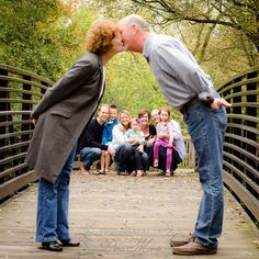 a man kissing a woman on the cheek while people watch