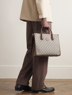 Gucci's tote bag combines the hallmarks of the 'Ophidia' collection from 2018 with the iconic 'GG Supreme' monogram from the 1930s. Made in Italy from durable coated-canvas and brown leather, it's built to hold its structured shape, fully lined in canvas and has the option of a shoulder strap or top handles. Luxury Double Handle Shoulder Bag In Signature Coated Canvas, High-end Monogram Canvas Bag For Formal Occasions, Formal Monogram Canvas Bag With Top Handle, High-end Formal Monogram Canvas Bag, Business Monogram Canvas Bags, Gucci Satchel With Top Carry Handle For Shopping, Classic Top Handle Bag In Monogram Canvas, Classic Monogram Canvas Top Handle Bag, Monogram Canvas Satchel With Double Handle