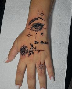 a woman's hand with a tattoo on it that says be brave and an eye