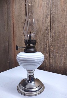 an old fashioned oil lamp on a white table