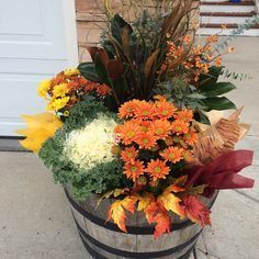 a wooden barrel filled with lots of colorful flowers