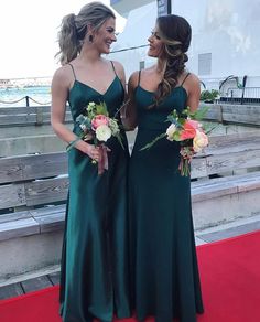 two beautiful women standing next to each other on a red carpet with flowers in their hands