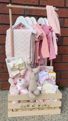 a wooden crate filled with baby items next to a brick wall