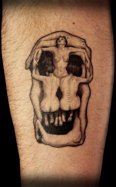 a man's arm with a skull tattoo on it and the image of two people hugging