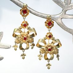 These late 19th century earrings were likely made in the Iberian peninsula. Hand crafted in gilded silver and set with bright red pastes, these beautiful danglers have wonderful movement when worn. They have screw backs but could be converted to posts on request. The bow and flower design is typical for earrings from this period and place.  These large and lovely earrings measure 59.5 mm north to south and 25.7 mm across, together they weigh 7.3 grams. Unmarked but carefully tested as silver.  I Antique Earrings With Historical Design For Ceremonial Occasions, Historical Design Earrings For Wedding, Antique Wedding Earrings With Historical Design, Ornate Red Jewelry For Ceremonial Occasions, Ornate Pendant Earrings For Ceremonial Occasions, Traditional Hallmarked Jewelry For Evening, Traditional Wedding Earrings With Historical Design, Gold Ruby Earrings For Evening, Red Victorian Jewelry For Ceremonial Occasions