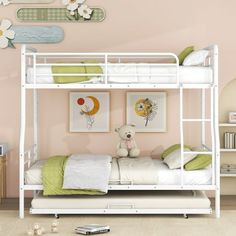 a white bunk bed sitting in a bedroom next to a wall with pictures on it