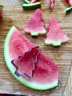 watermelon slices cut into christmas trees on a cutting board