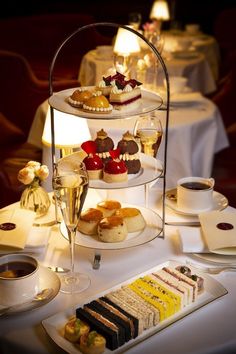 three tiered trays filled with different types of desserts and drinks on a table