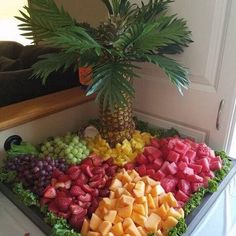 a fruit platter with grapes, strawberries, pineapples and bananas