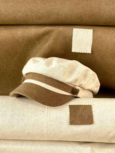 Classic and elegant natural linen sailor cap in beige with brown cotton canvas visor. Adorned with a ribbon of the same fabric as the visor and riveted with metallic buttons in old gold color. Cut and sewn on the bias with a quality linen fabric and finished with a very light cotton lining. The length of the visor is 4.5 centimeters. The back of the cap has a small eco-leather belt to adjust the measurement up to three centimeters less. It adapts very well to the head. For its production we use Beige Flat Brim Hat One Size Fits Most, Beige Flat Brim Hat One Size, Vintage Beige Visor Hat, Beige Flat Cap, One Size Fits Most, Beige Flat Cap One Size Fits Most, One Size Fits Most Beige Flat Cap, Classic Beige Flat Cap, Vintage Beige Cap, Beige Flat Cap