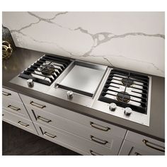 two burners are on top of the stove in this kitchen with marble counter tops