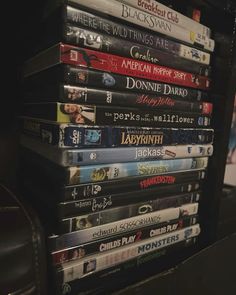 a stack of dvd's sitting on top of a table next to a chair